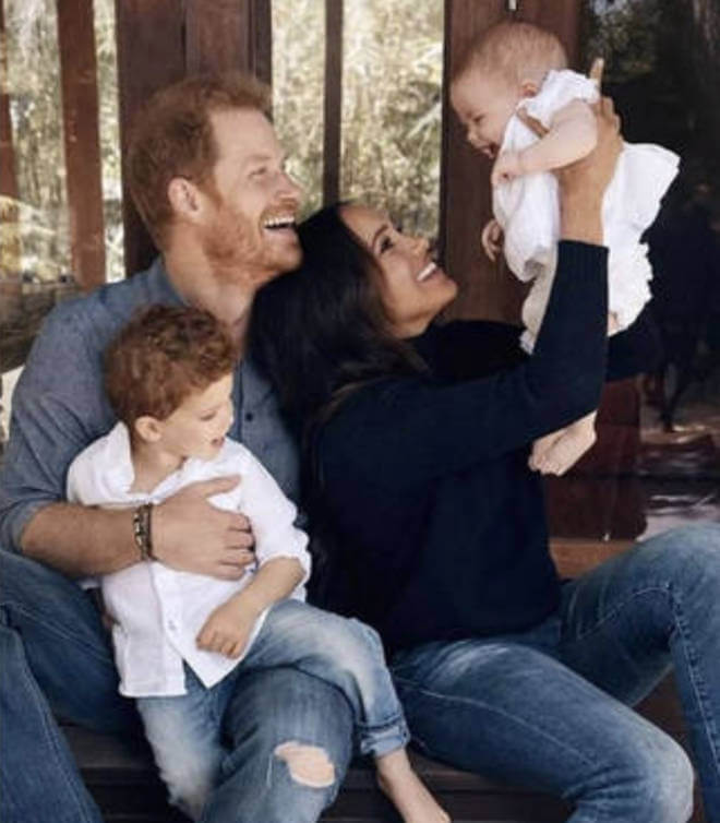 Harry and Meghan, in casual attire, laughing with their two children.